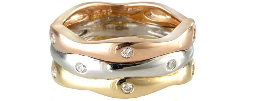 Three gold rings with diamond accents on a white background