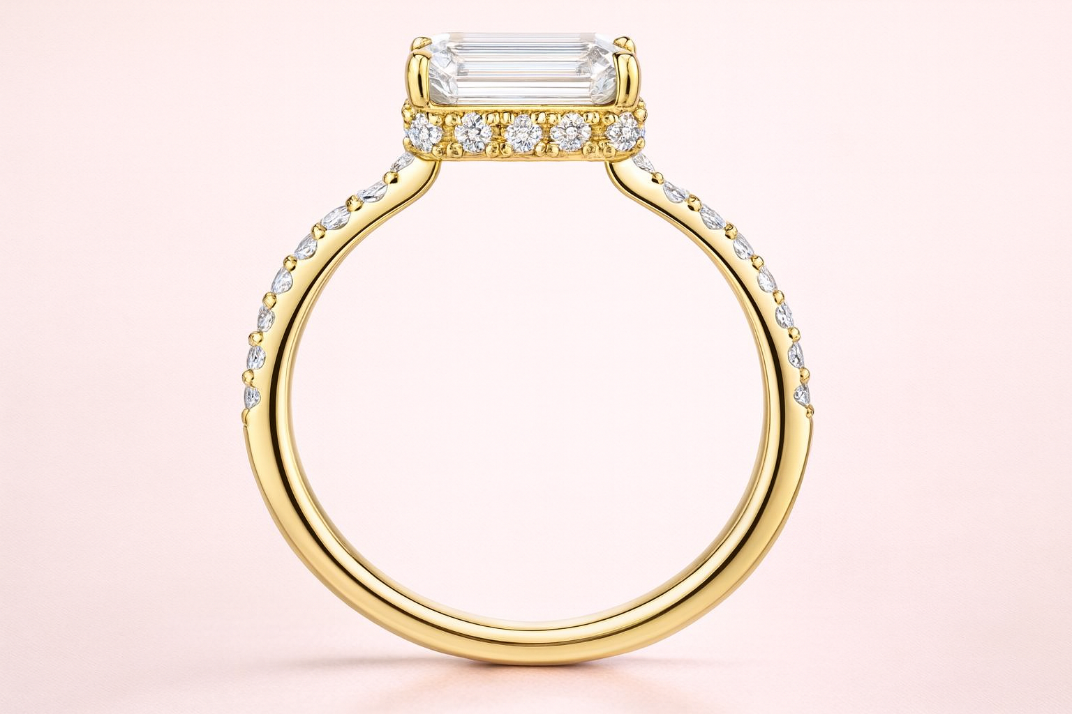 Gold ring with a large lab grown diamond on a light pink background