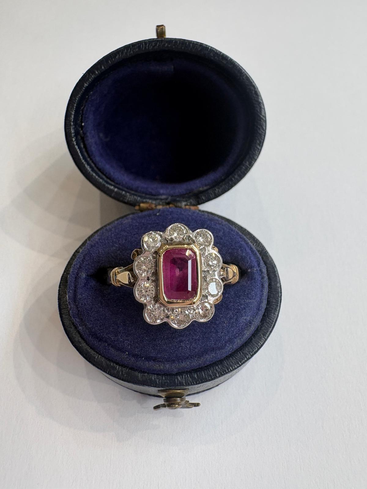 Bezel set emerald cut ruby ring with bezel set diamonds in an antique velvet box
