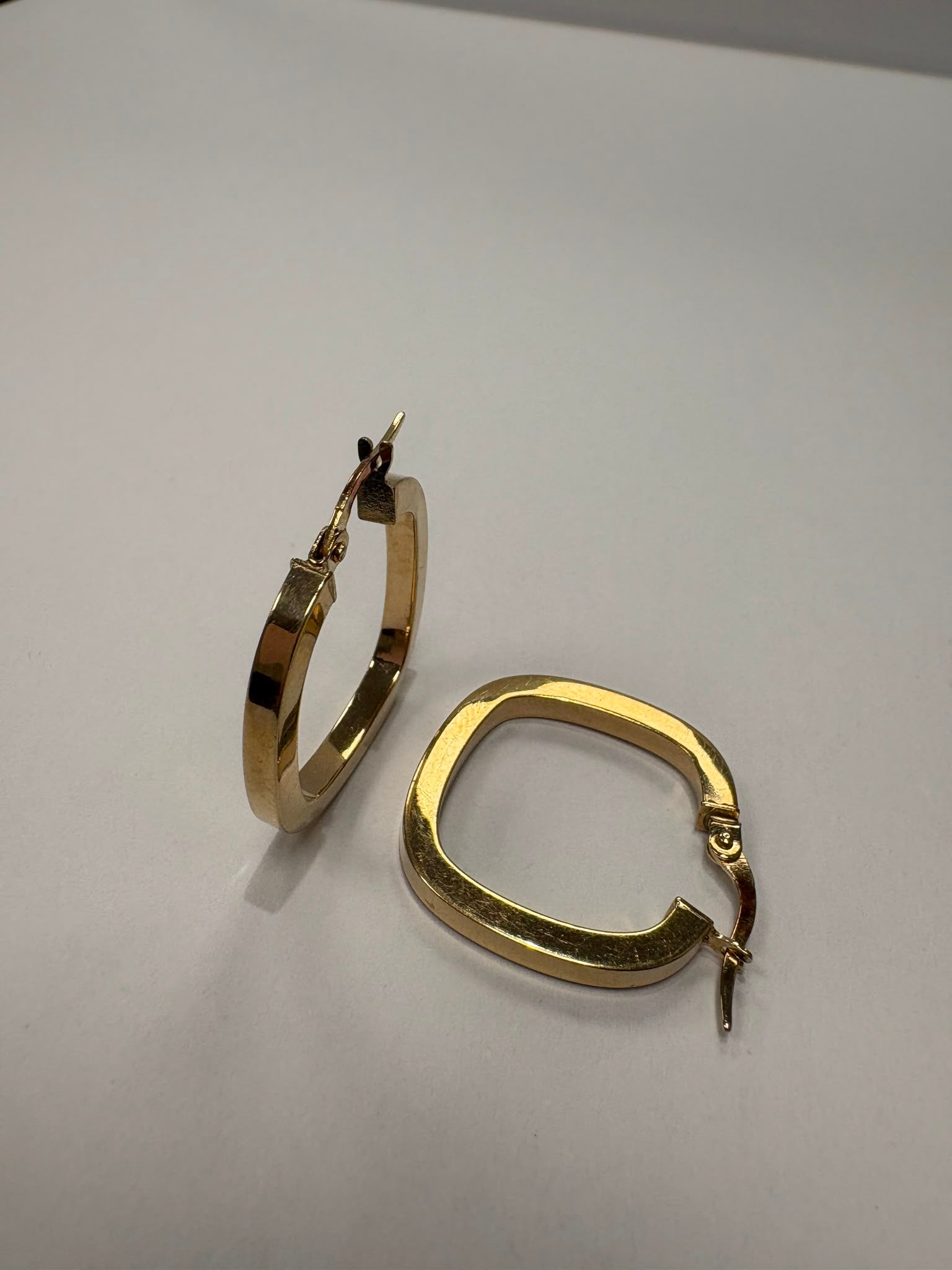 Preloved 9ct yellow gold square profile hoop earrings with hinged click clasp shown on earring stand and loose on white background, available at Fogal & Barnes Harrogate