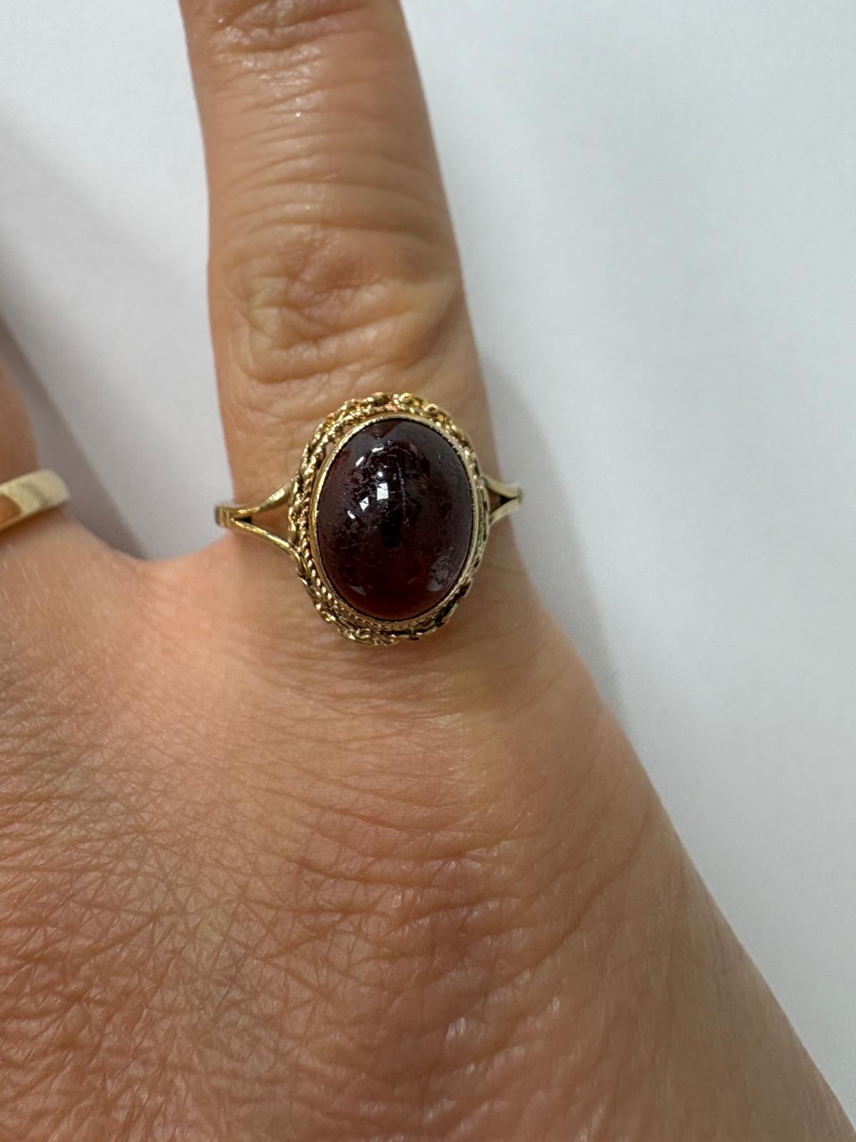 9ct gold garnet cabochon ring showing rich red stone under studio light