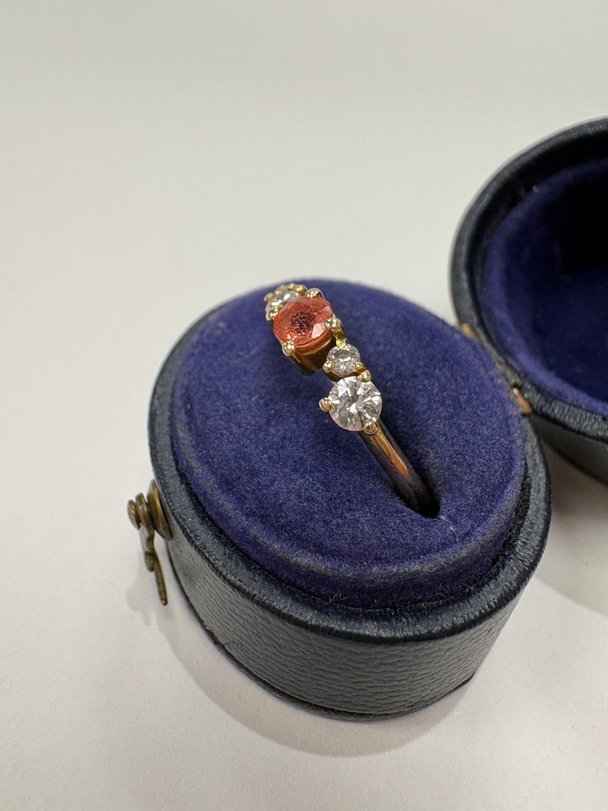 Side view of orange sapphire and moissanite ring