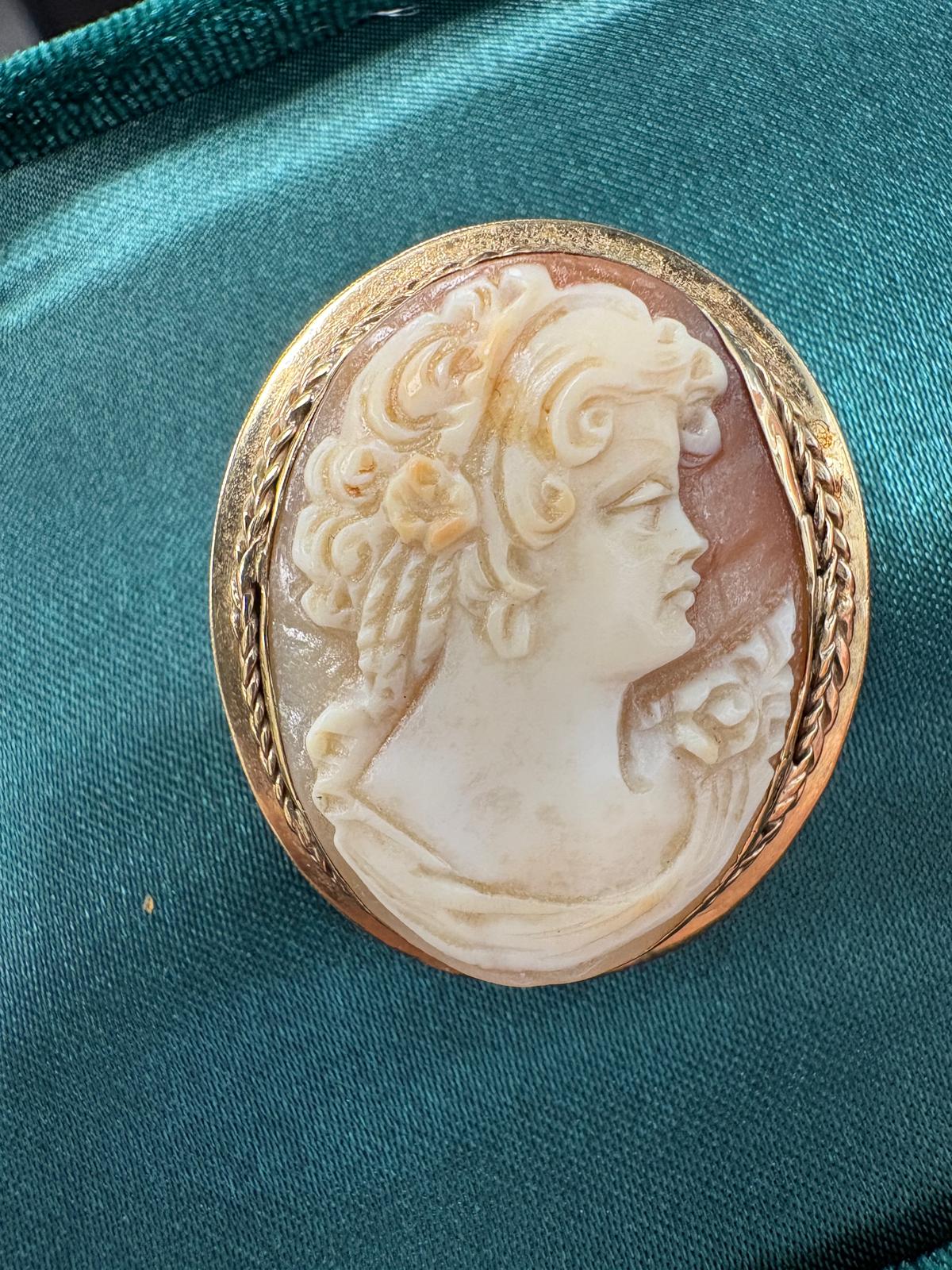 Pre-loved Victorian 9ct yellow gold carved shell cameo brooch circa 1860 on teal silk — front view showing classical female bust portrait