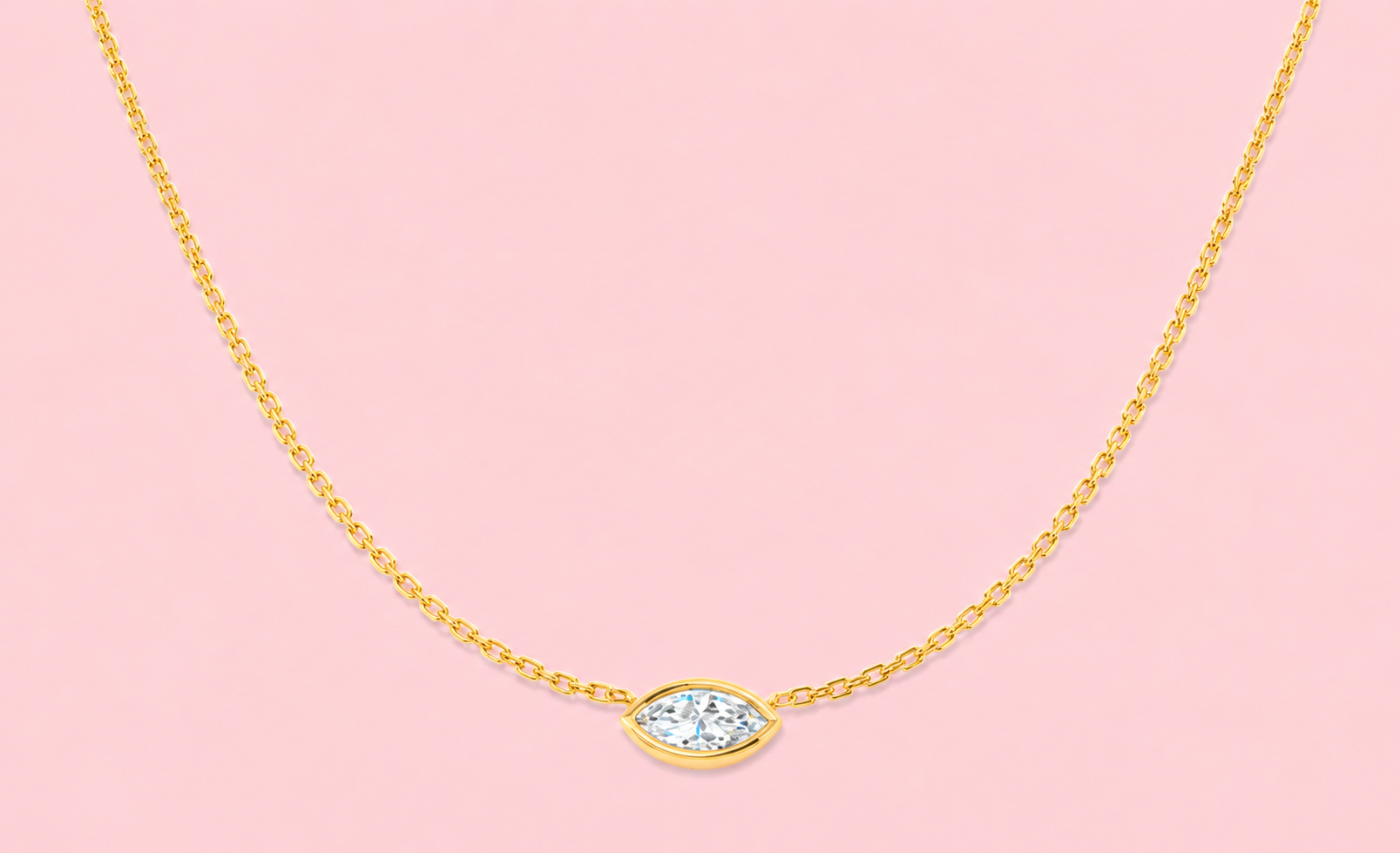 Bezel set lab grown marquise diamond solitaire necklace shown in yellow gold and white gold on a pink background, 0.57ct single stone pendant