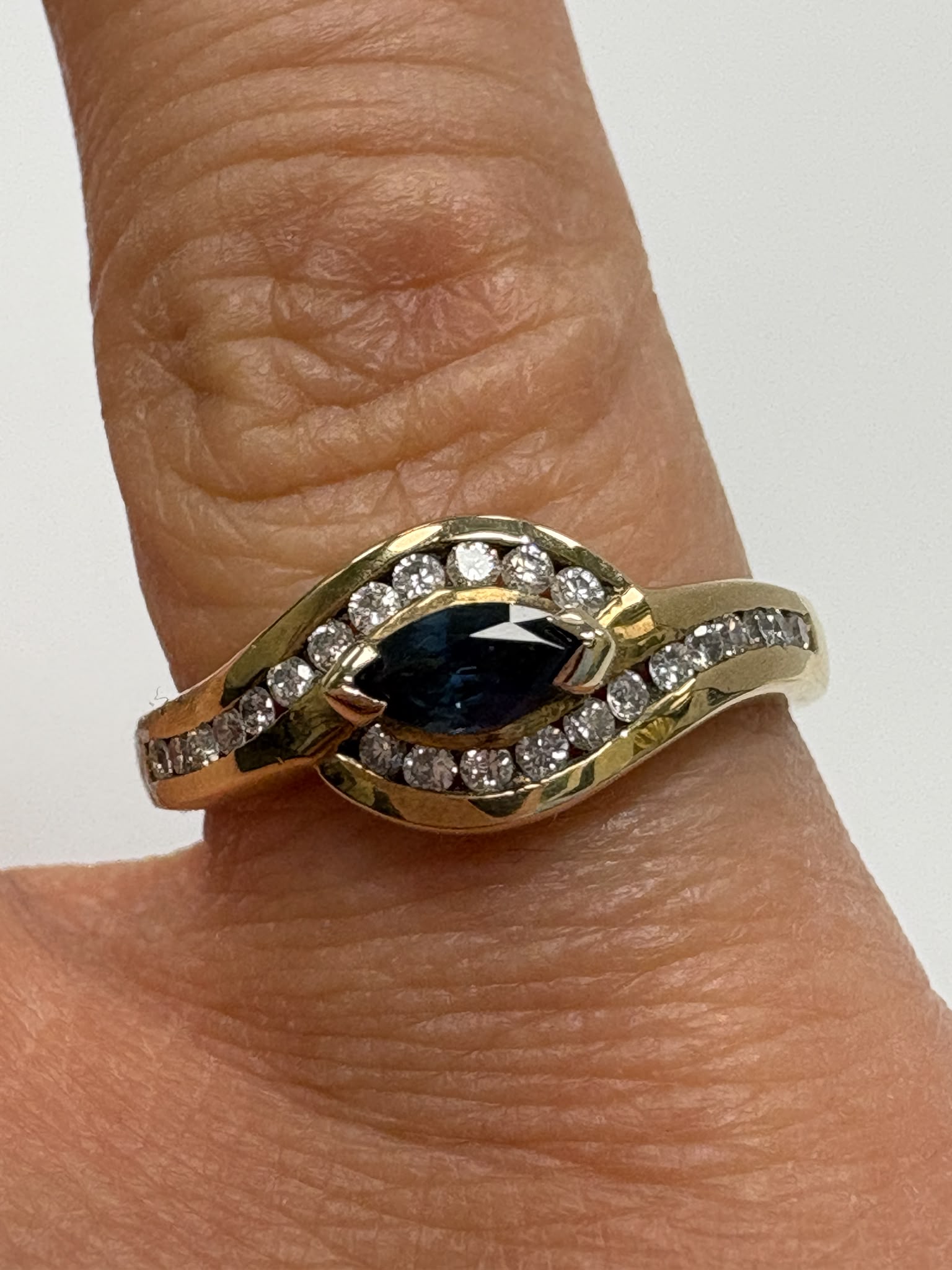A pre-loved 9ct gold marquise sapphire and diamond ring, channel set, size O. Genuine sapphire and diamonds, excellent condition. Shop second hand fine jewellery in Harrogate.