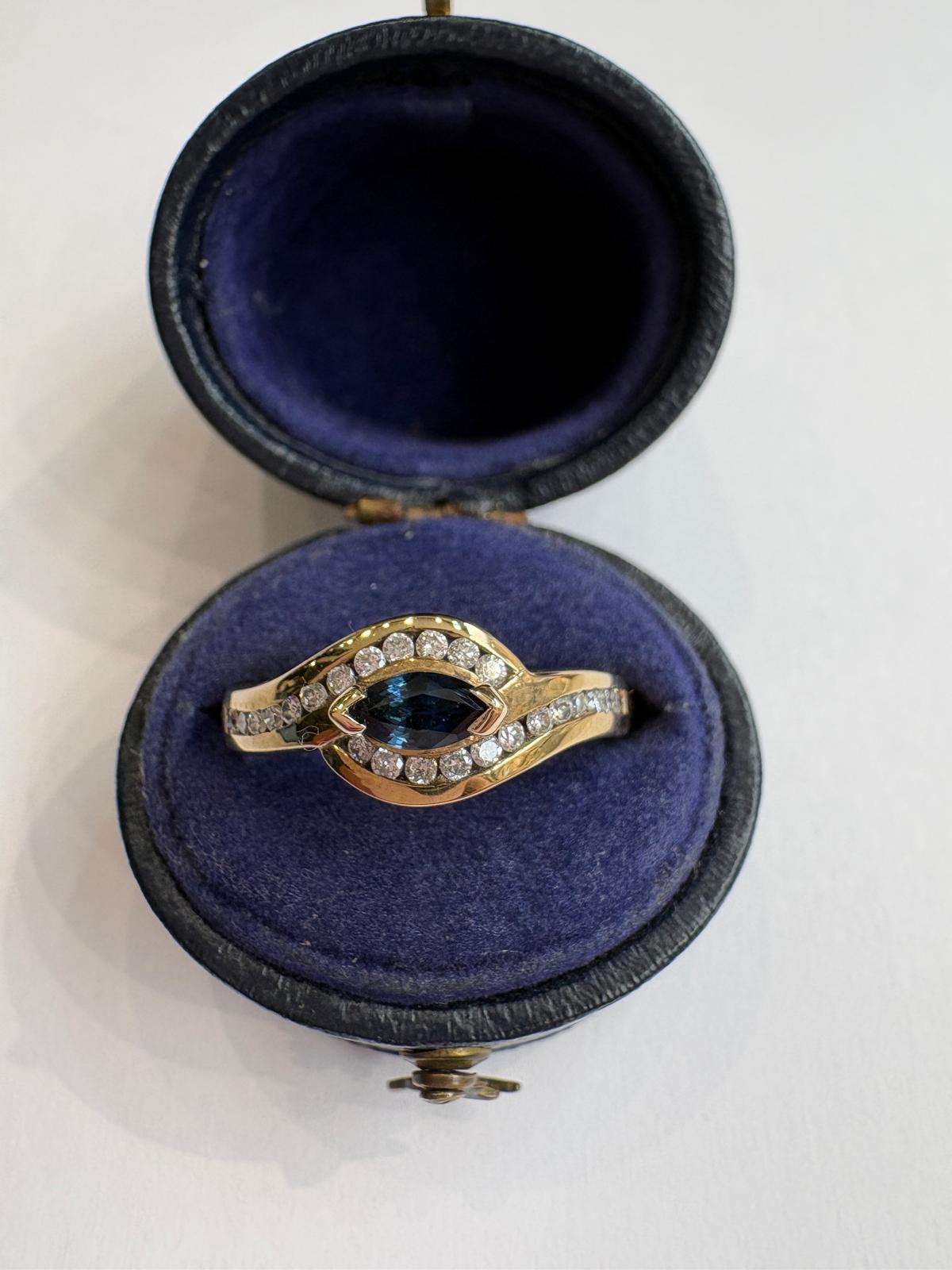 A pre-loved 9ct gold marquise sapphire and diamond ring, channel set, size O. Genuine sapphire and diamonds, excellent condition. Shop second hand fine jewellery in Harrogate.