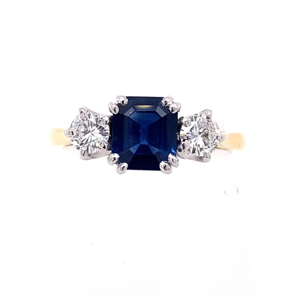 Blue octagonal sapphire and diamond three stone trilogy engagement ring set on 18k yellow gold from fogal and barnes fine jewellers of Harrogate.