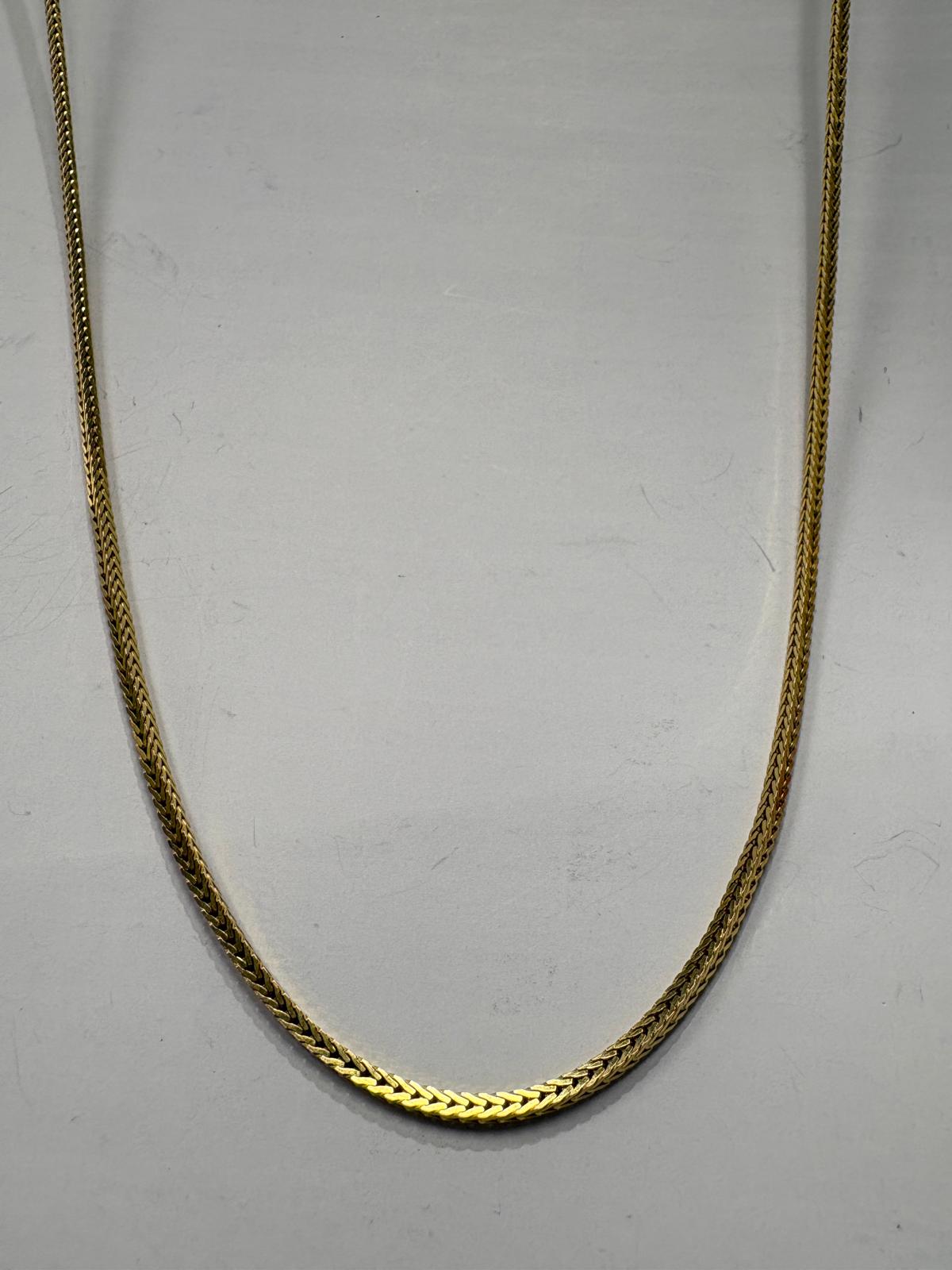Gold chain on a light gray background