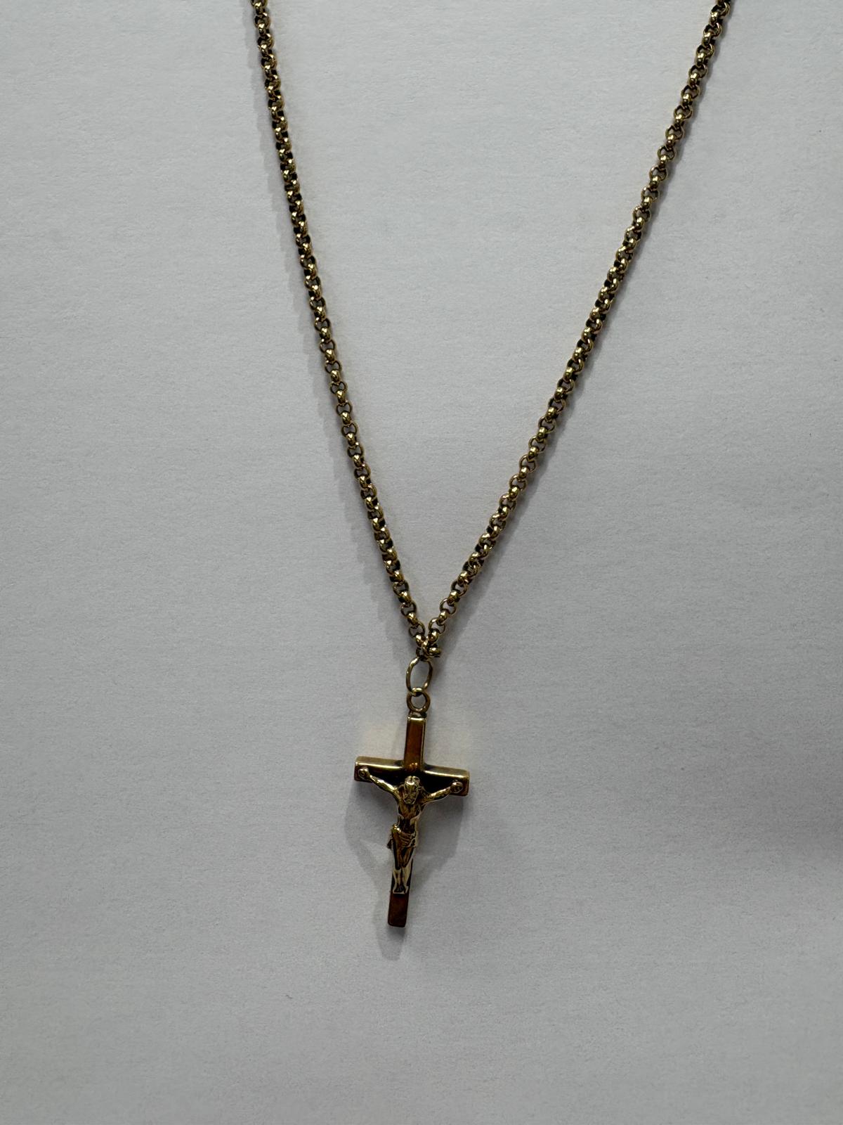 Close-up front view of a yellow gold crucifix pendant suspended from a yellow gold belcher chain. The cross has a flat polished finish with bevelled edges and features a detailed three-dimensional corpus of Christ with outstretched arms.
