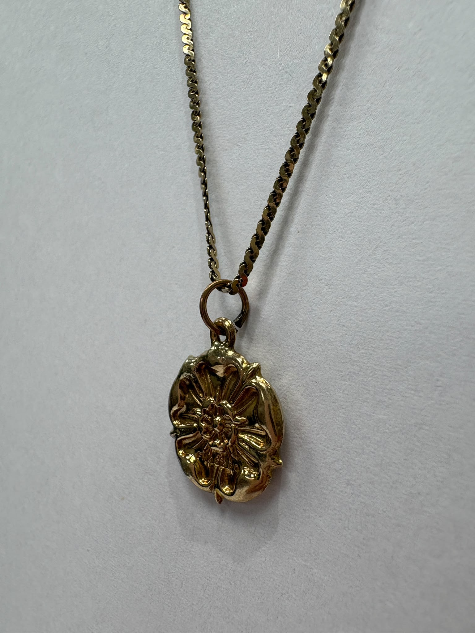9ct gold Yorkshire Rose necklace laid flat in a circle on white background