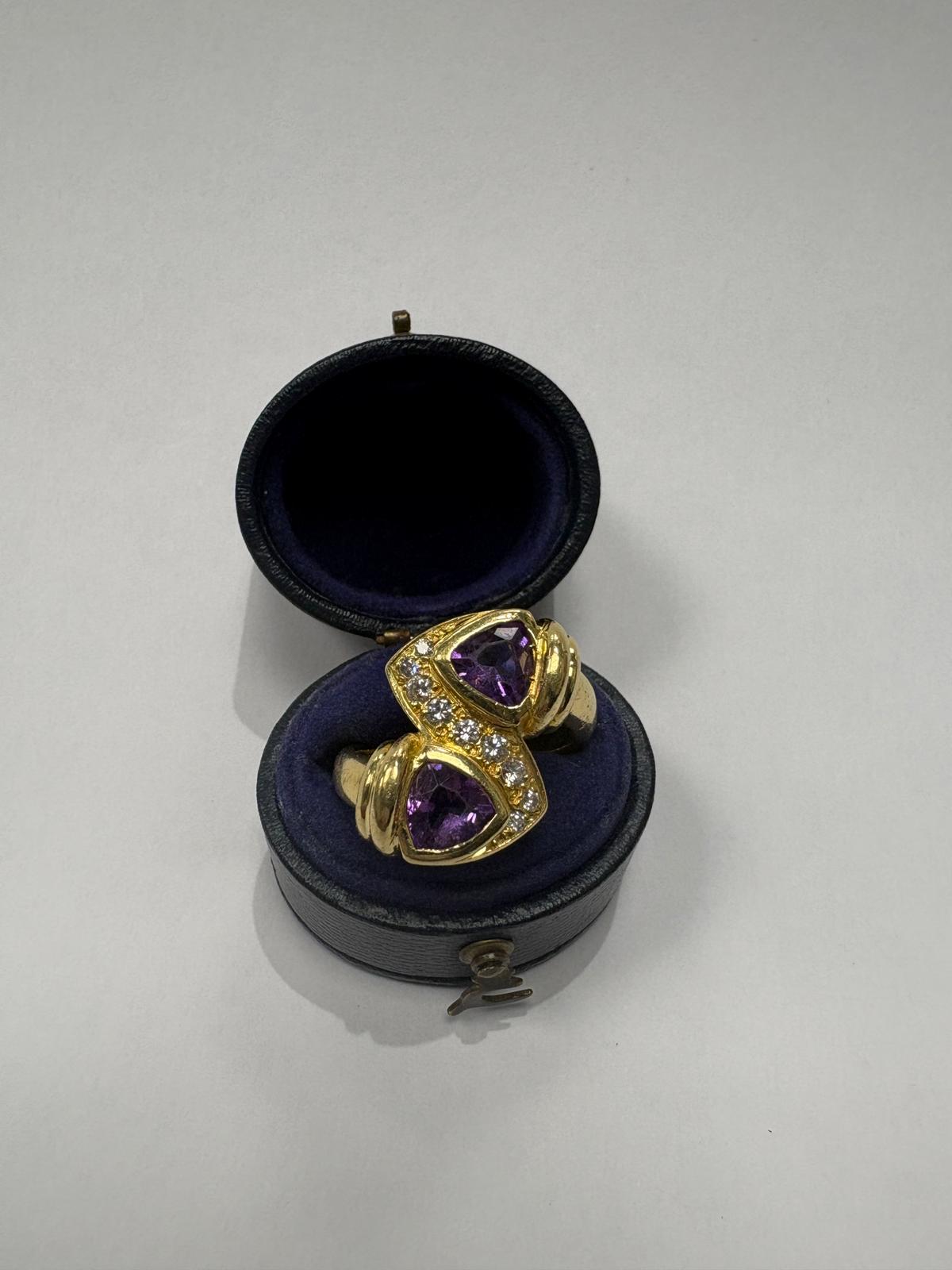 Pre-loved 18ct yellow gold toi et moi ring with two trilliant-cut natural amethysts and diamond bridges, size N