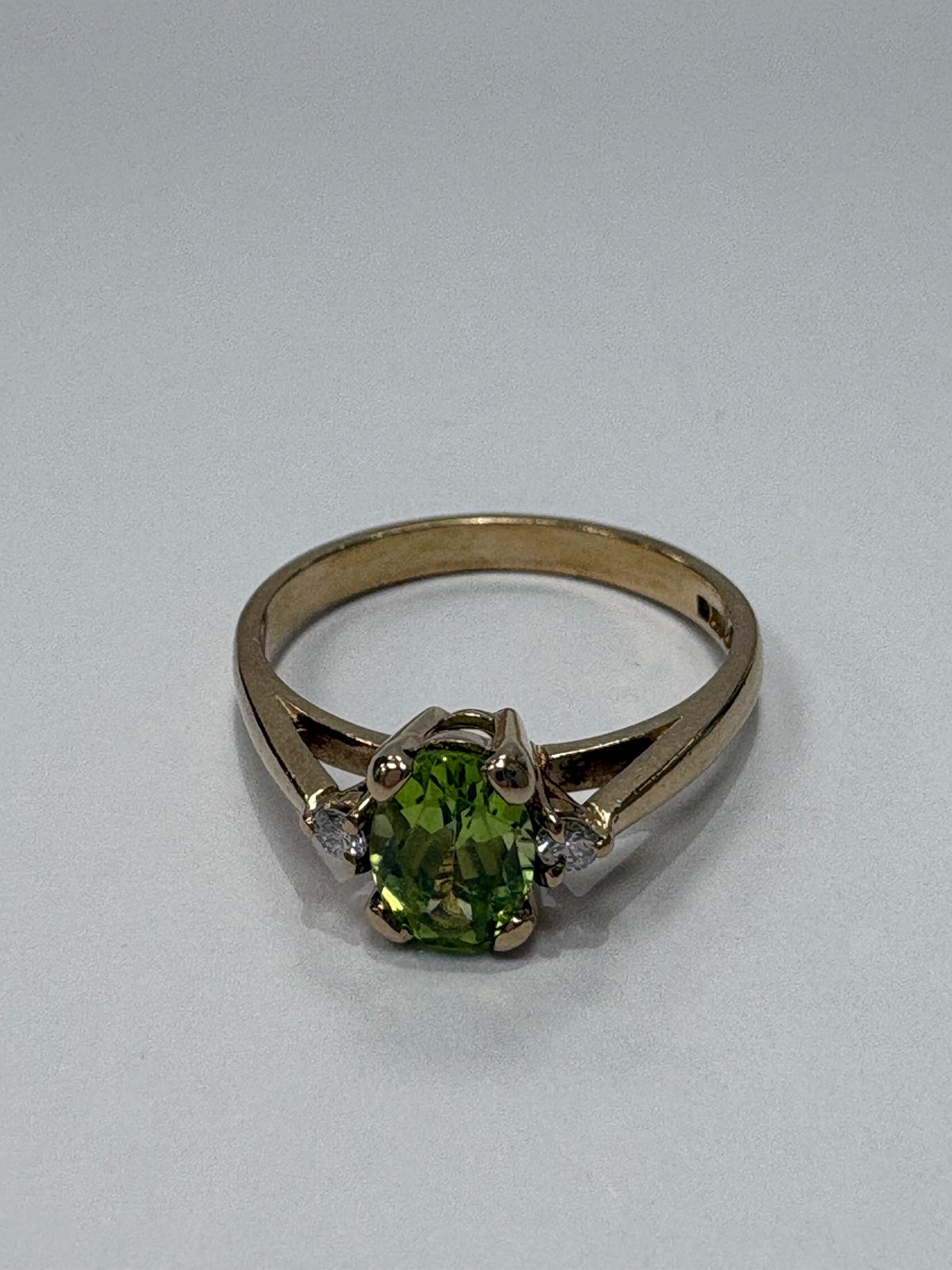 Flat lay of 9ct gold green gemstone ring showing full band