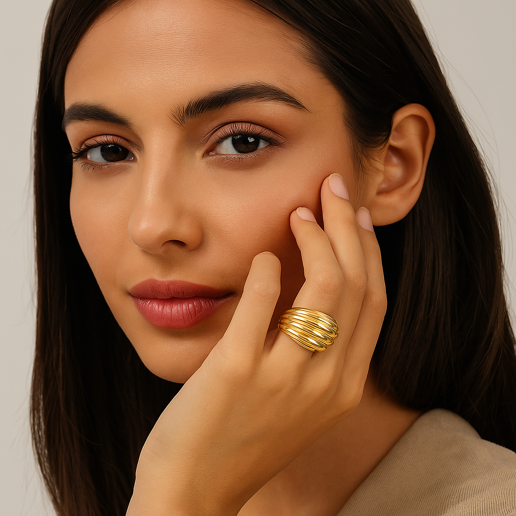 Woman wearing a gold ring on her finger, touching her face.