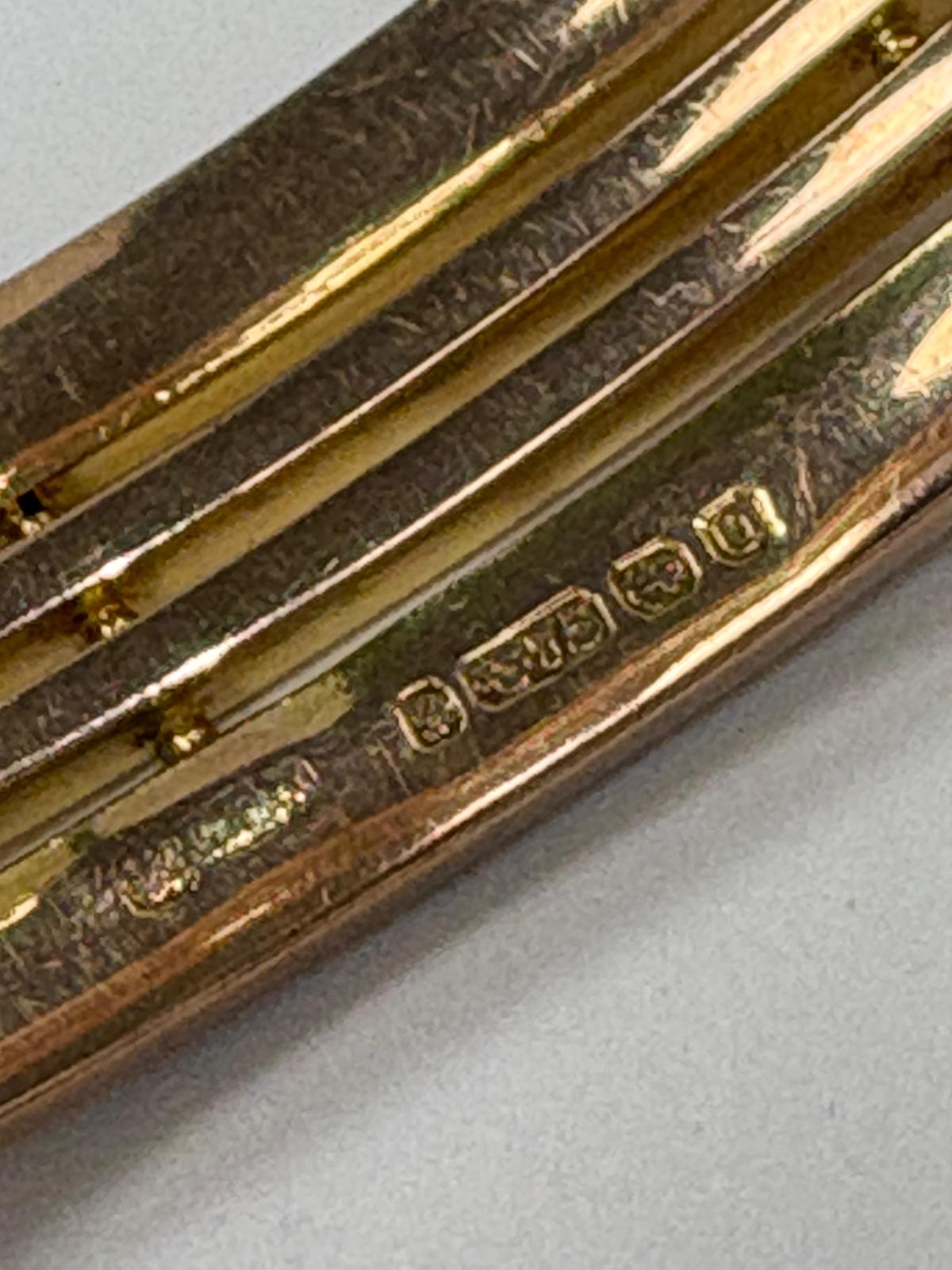 Detailed view of 9ct gold hallmark on vintage gate bangle