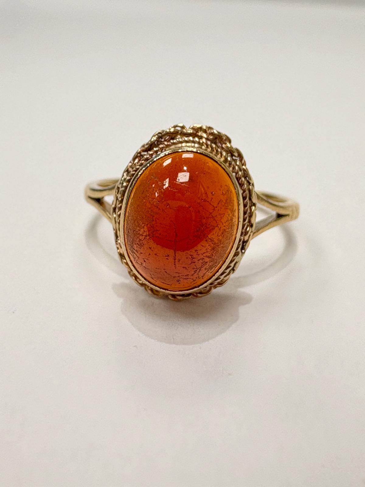 Vintage 9ct gold cabochon garnet ring worn on hand, rope-twist gallery setting
