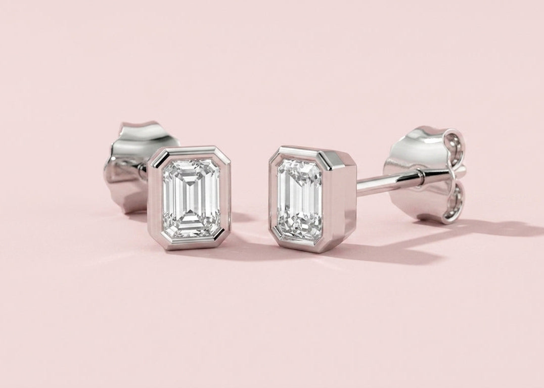 Bezel set lab grown emerald cut diamond stud earrings shown in white gold, 0.5ct 