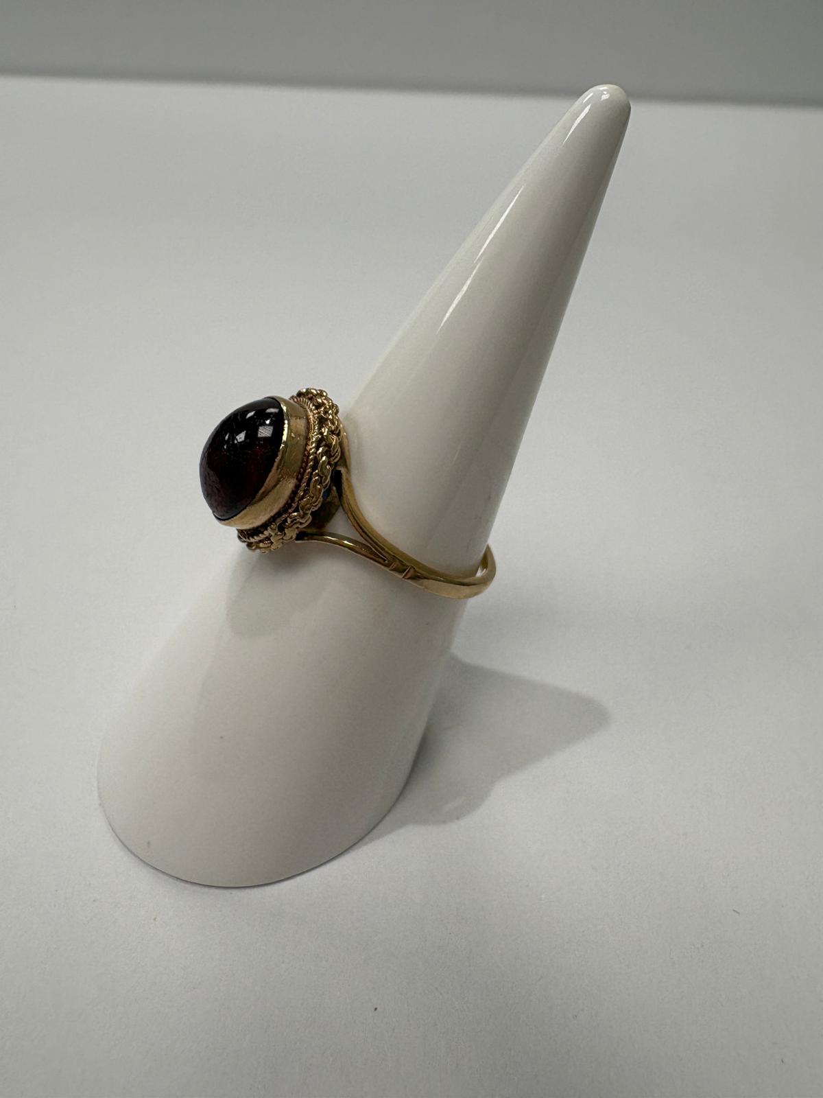 Cabochon garnet ring displayed on ring cone, side profile, 9ct gold
