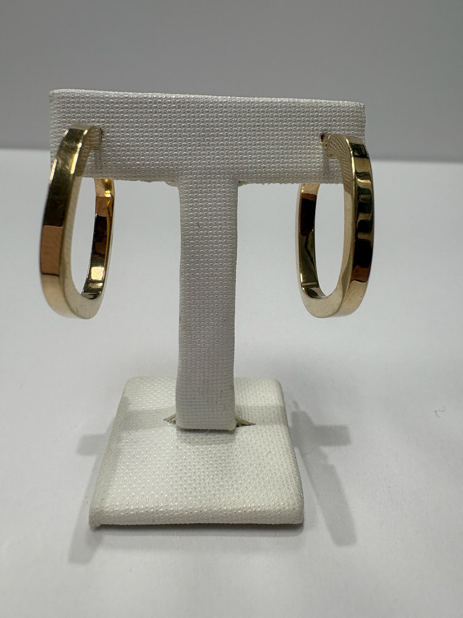 Preloved 9ct yellow gold square profile hoop earrings with hinged click clasp shown on earring stand and loose on white background, available at Fogal & Barnes Harrogate