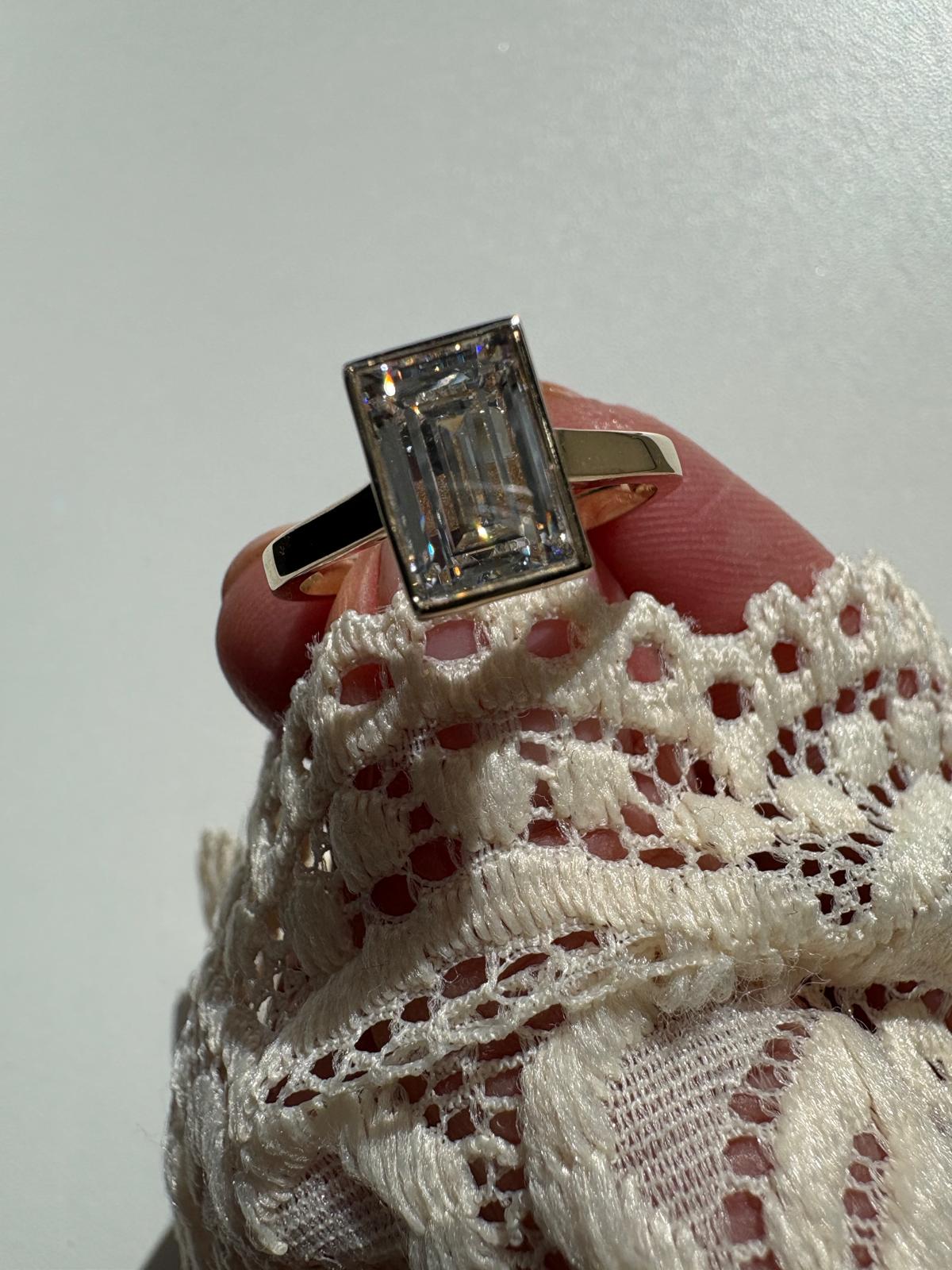 Yellow gold bezel set lab grown diamond engagement ring emerald cut 