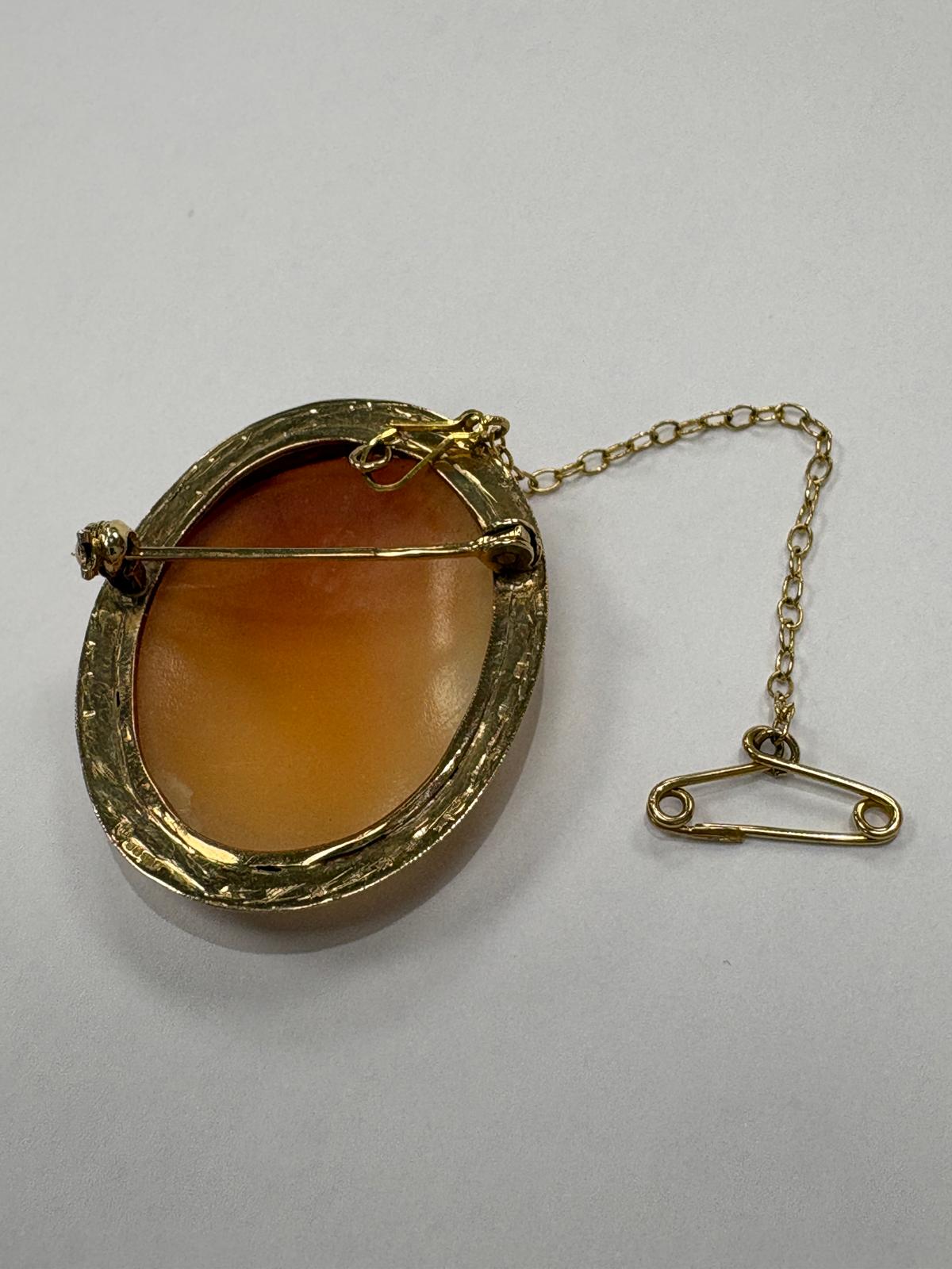 Victorian 9ct gold carved shell cameo brooch with gold safety chain — classical female profile with detailed rope border mount