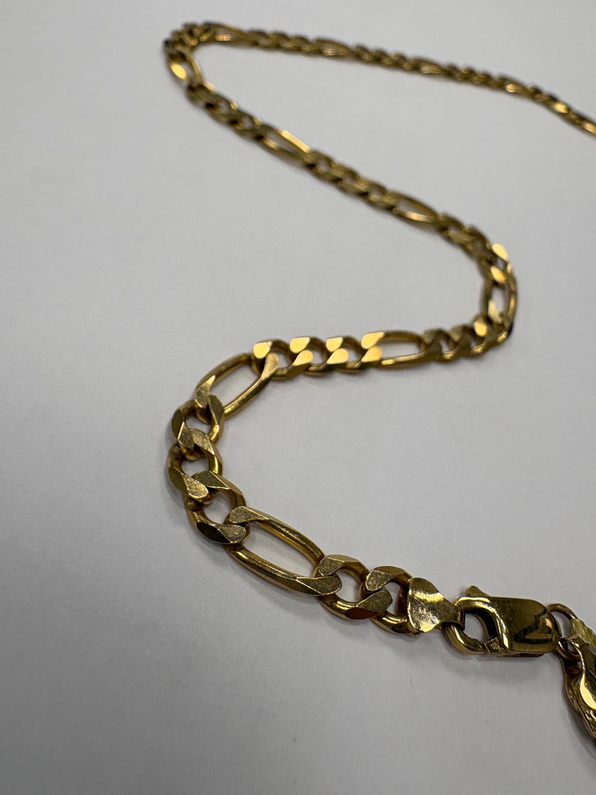 Close-up view of the lobster clasp end of a pre-loved yellow gold heavy figaro chain necklace laid on a white surface. The large lobster clasp is clearly visible alongside the bold figaro link pattern of the chain.