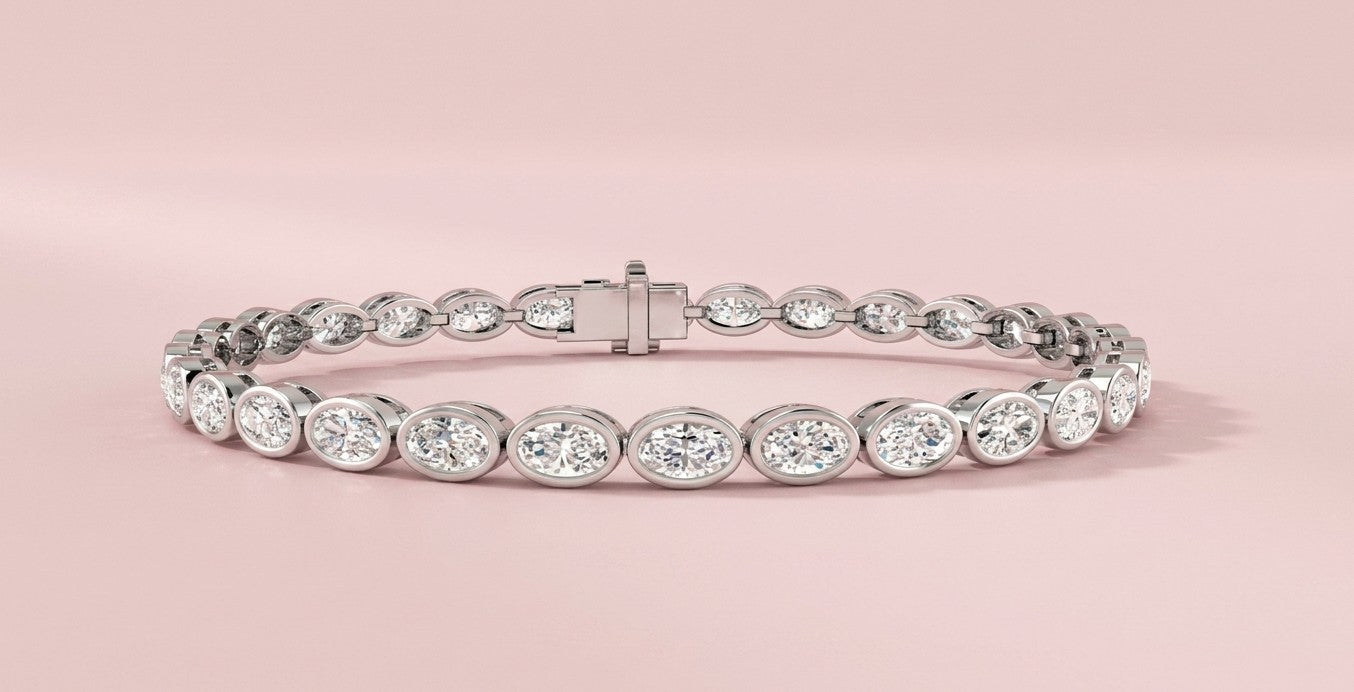Lab grown east-west oval diamond tennis bracelet featuring 30 horizontally bezel set oval diamonds totalling 5.69ct, shown in white gold and yellow gold with CAD design detail