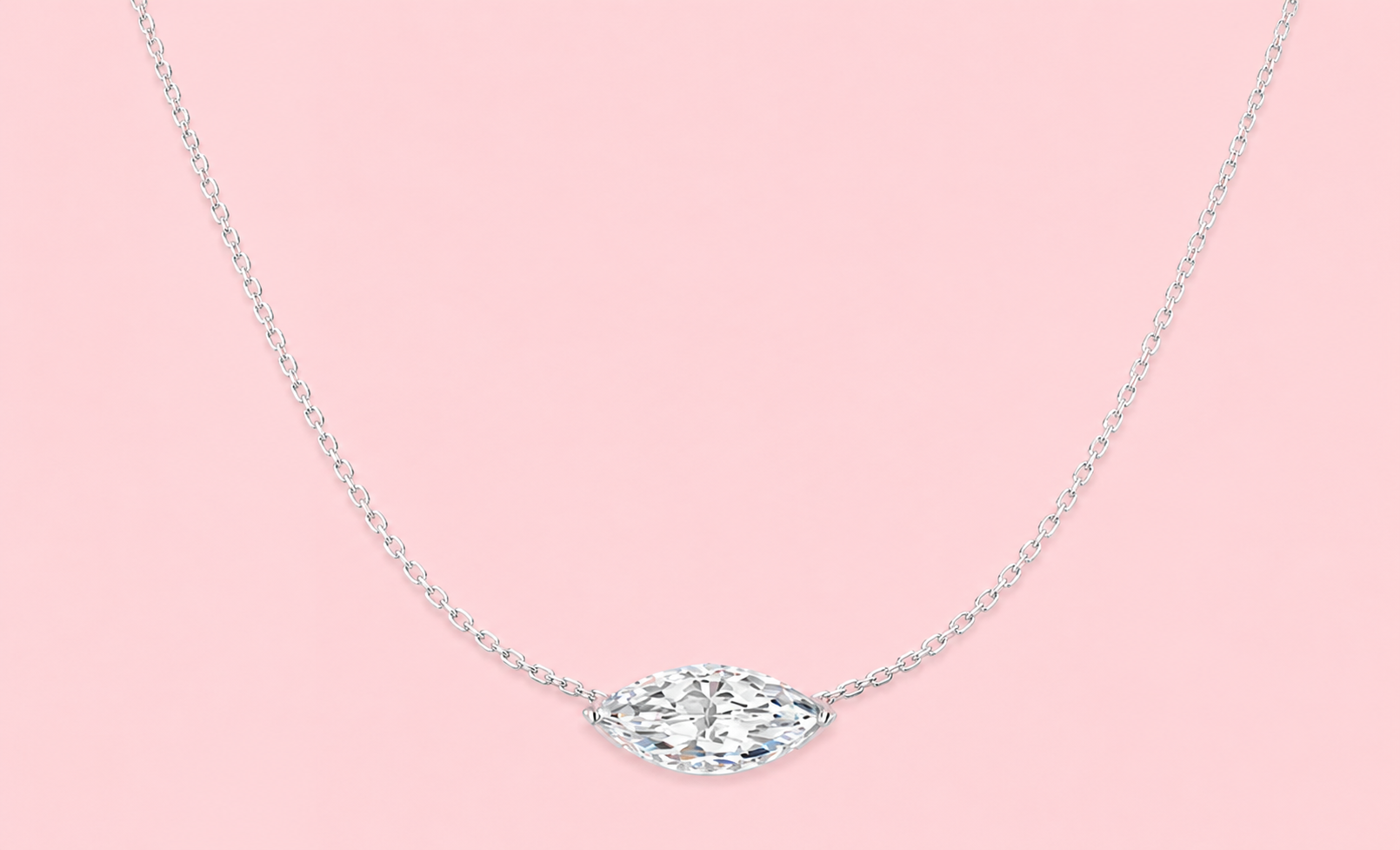 Lab grown marquise diamond pendant necklace with hidden halo of round brilliant diamonds shown in yellow gold and white gold versions on a pink background