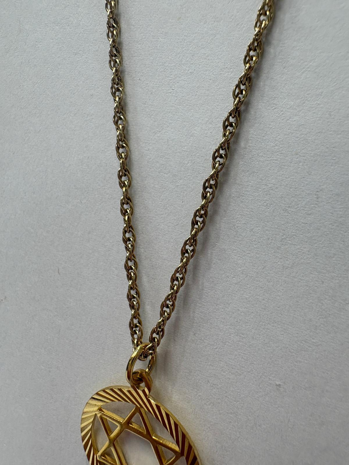 Macro shot of UK hallmark stamps on gold Star of David pendant