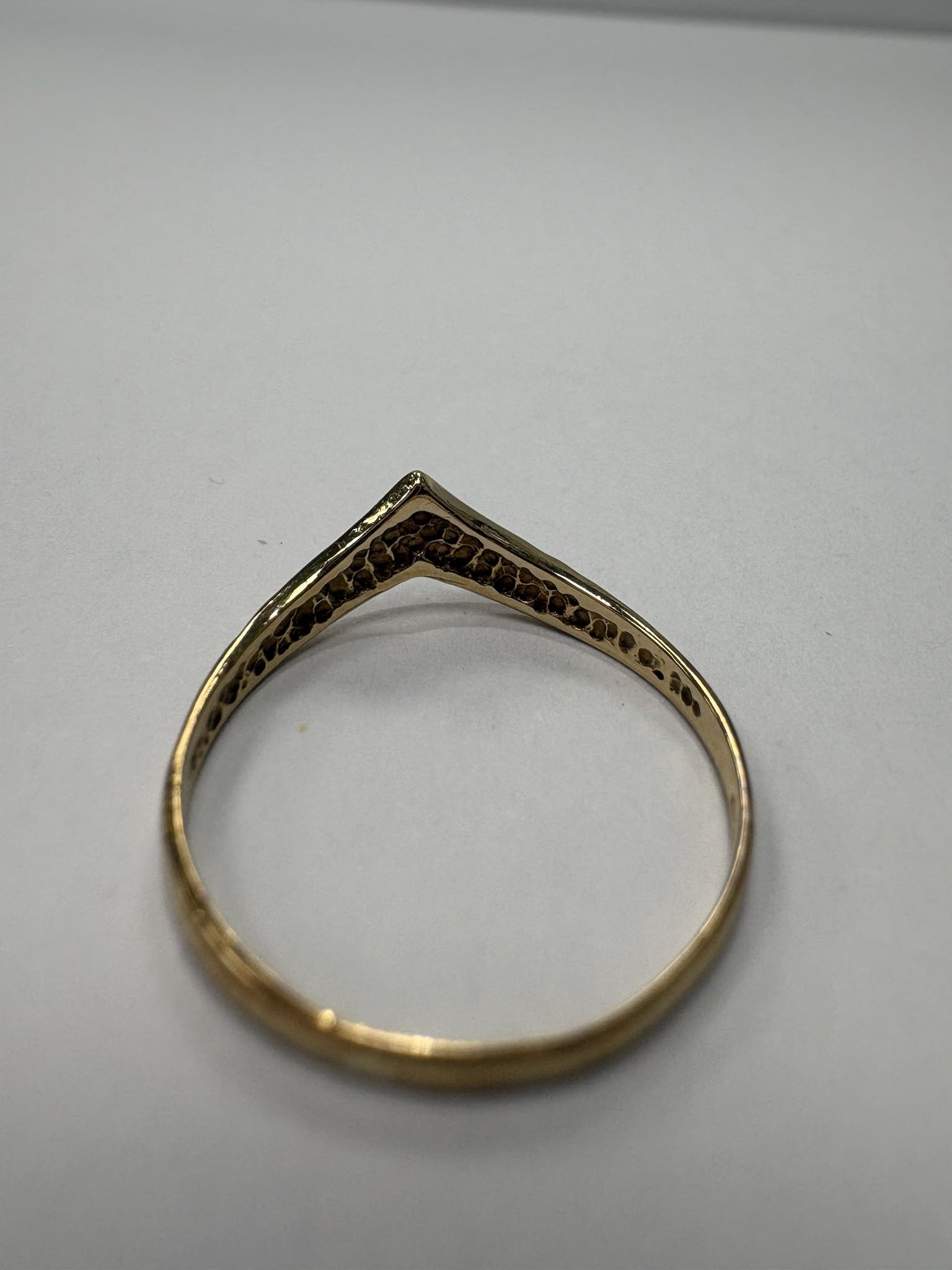 Preloved 9ct yellow gold engraved wishbone ring with half engraved detailing shown on white background and worn on finger, size S, available at Fogal & Barnes Harrogate