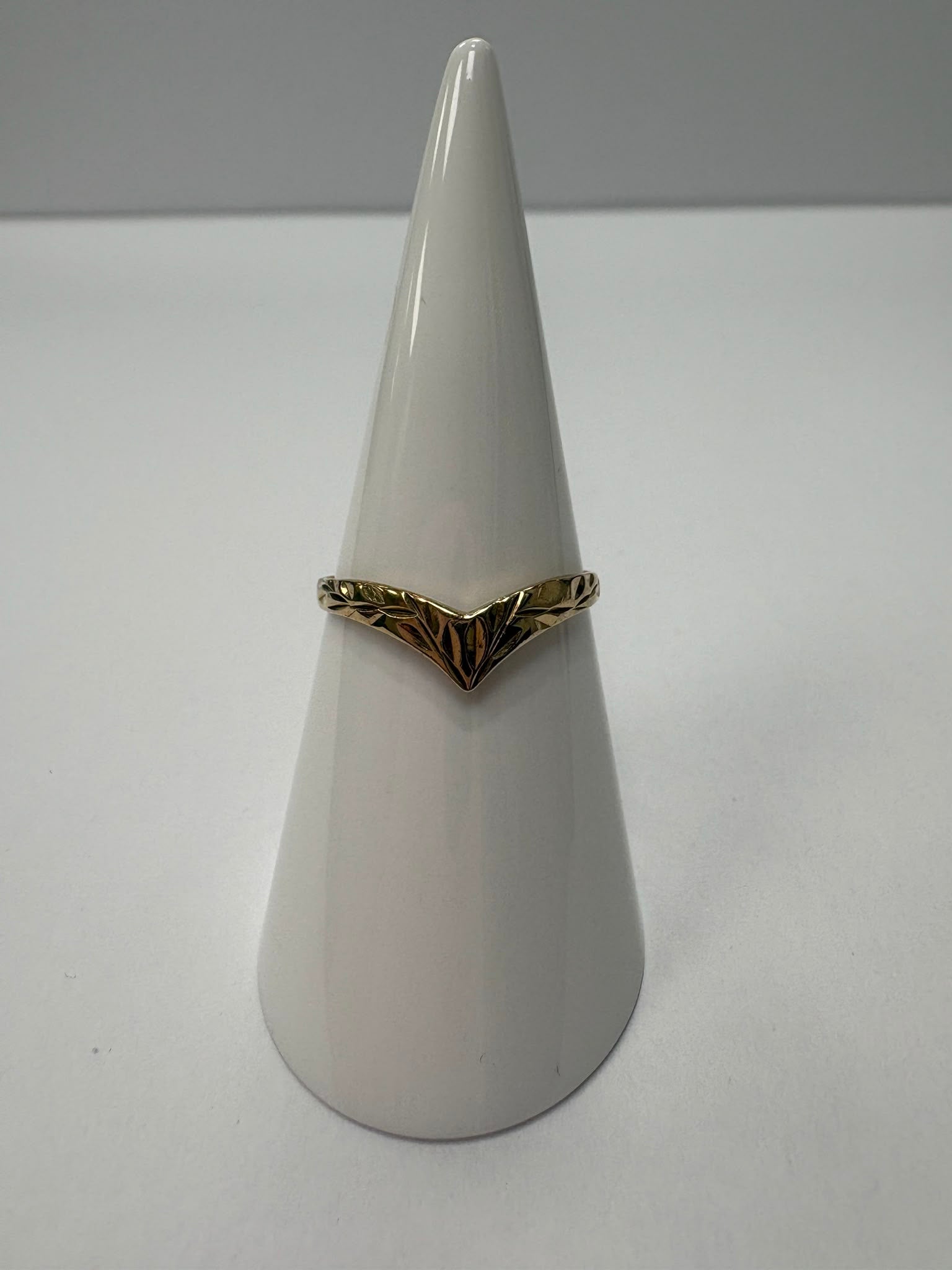 Preloved 9ct yellow gold engraved wishbone ring with half engraved detailing shown on white background and worn on finger, size S, available at Fogal & Barnes Harrogate