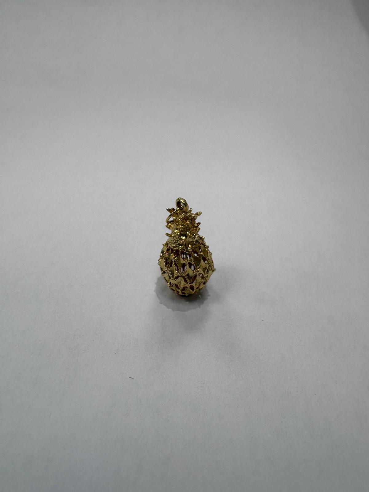 Gold pineapple-shaped pendant on a light gray background
