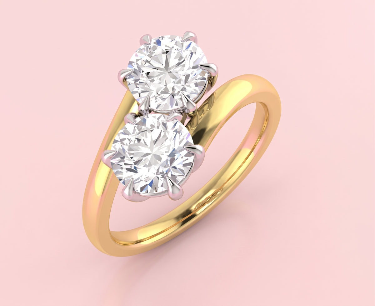 Vintage inspired toi et moi lab grown diamond ring with two round brilliant diamonds in six claw settings on a crossover gold band, viewed from above