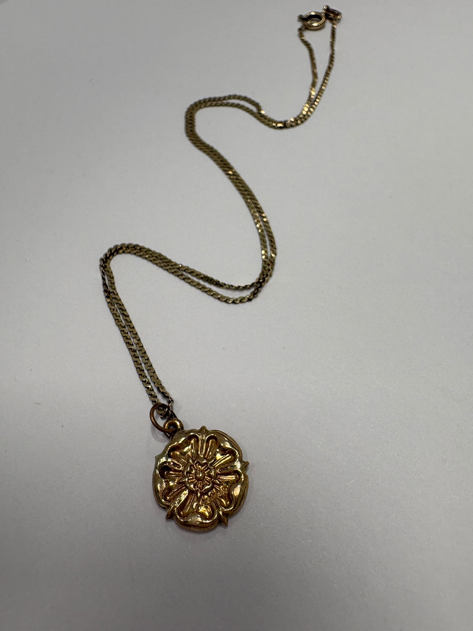 Close-up of 9ct gold Yorkshire Rose pendant showing petal detail and hallmark