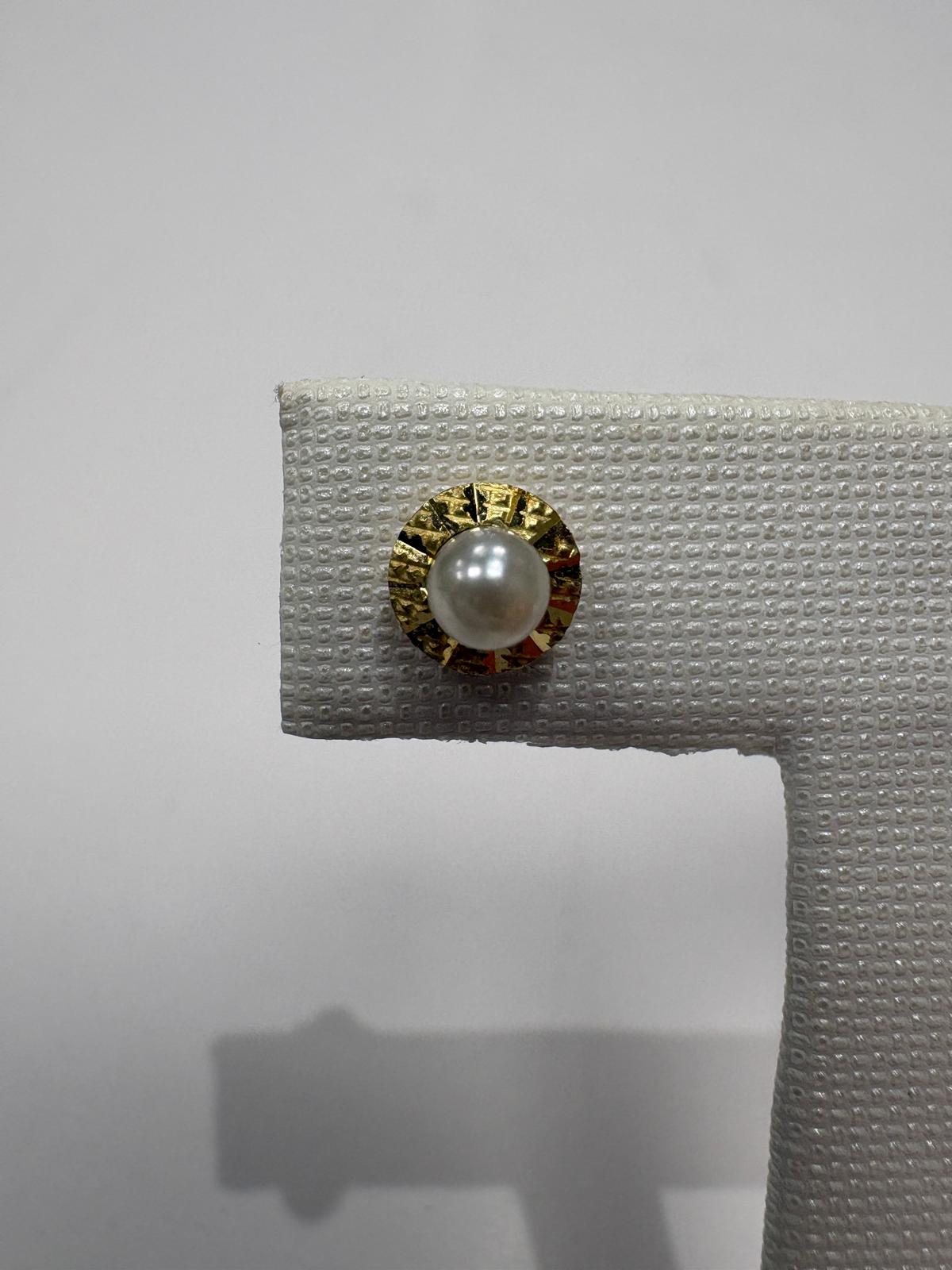 Gold earring with a pearl on a white background