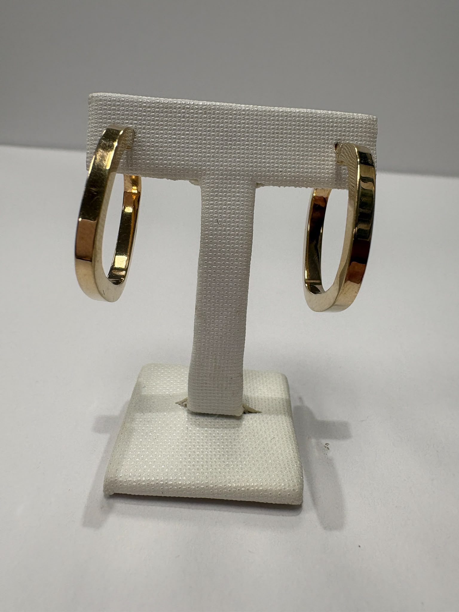 Preloved 9ct yellow gold square profile hoop earrings with hinged click clasp shown on earring stand and loose on white background, available at Fogal & Barnes Harrogate