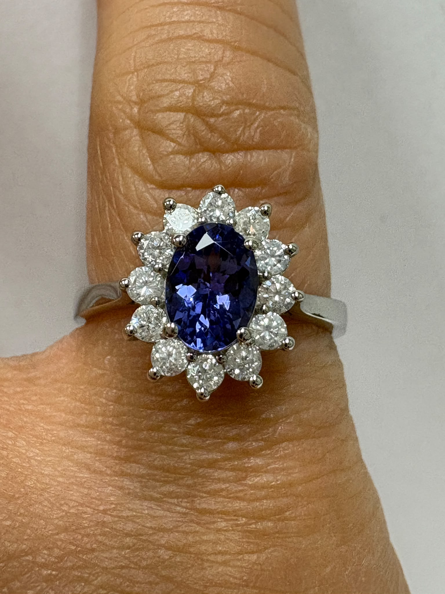Genuine pre-loved tanzanite and diamond cluster ring in 9ct white gold. 0.81ct tanzanite, 0.42ct diamonds, size M. Visit our Harrogate showroom today.