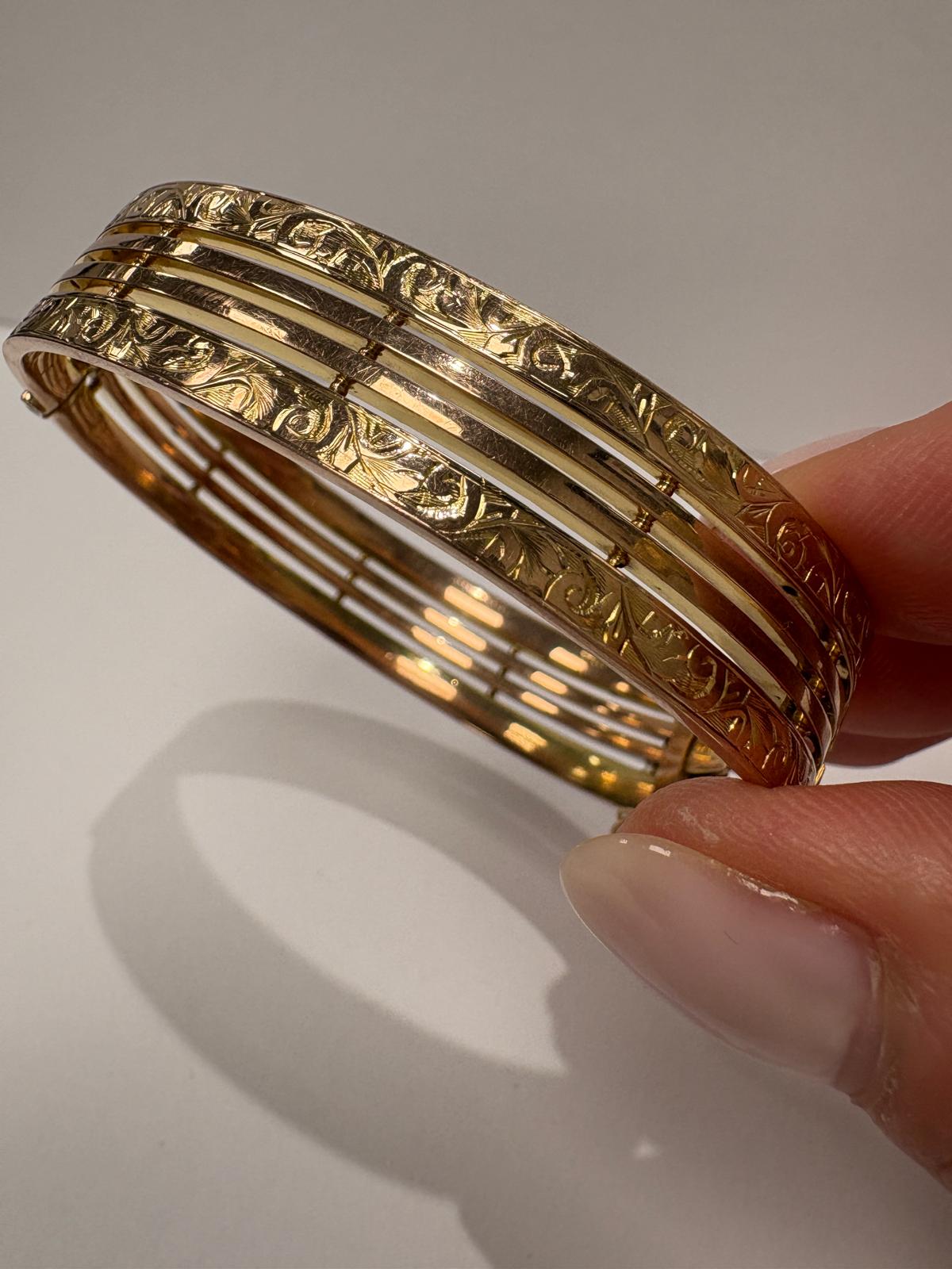 Detail of hand engraved leaf and scroll on vintage 9ct gold gate bangle