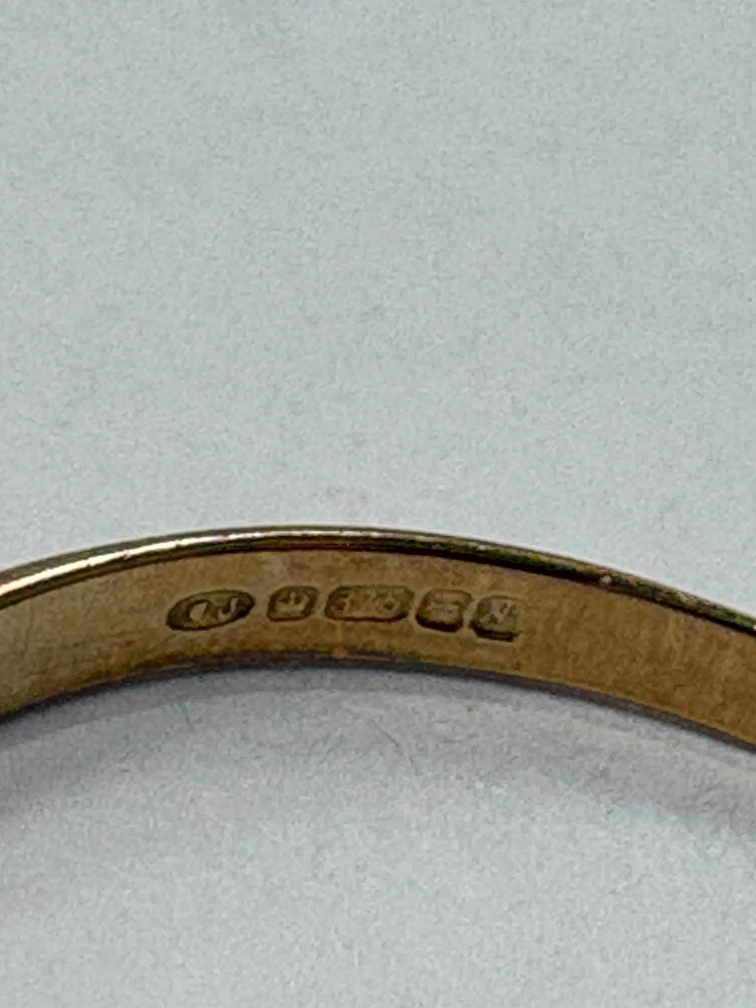 Preloved 9ct yellow gold engraved wishbone ring with half engraved detailing shown on white background and worn on finger, size S, available at Fogal & Barnes Harrogate